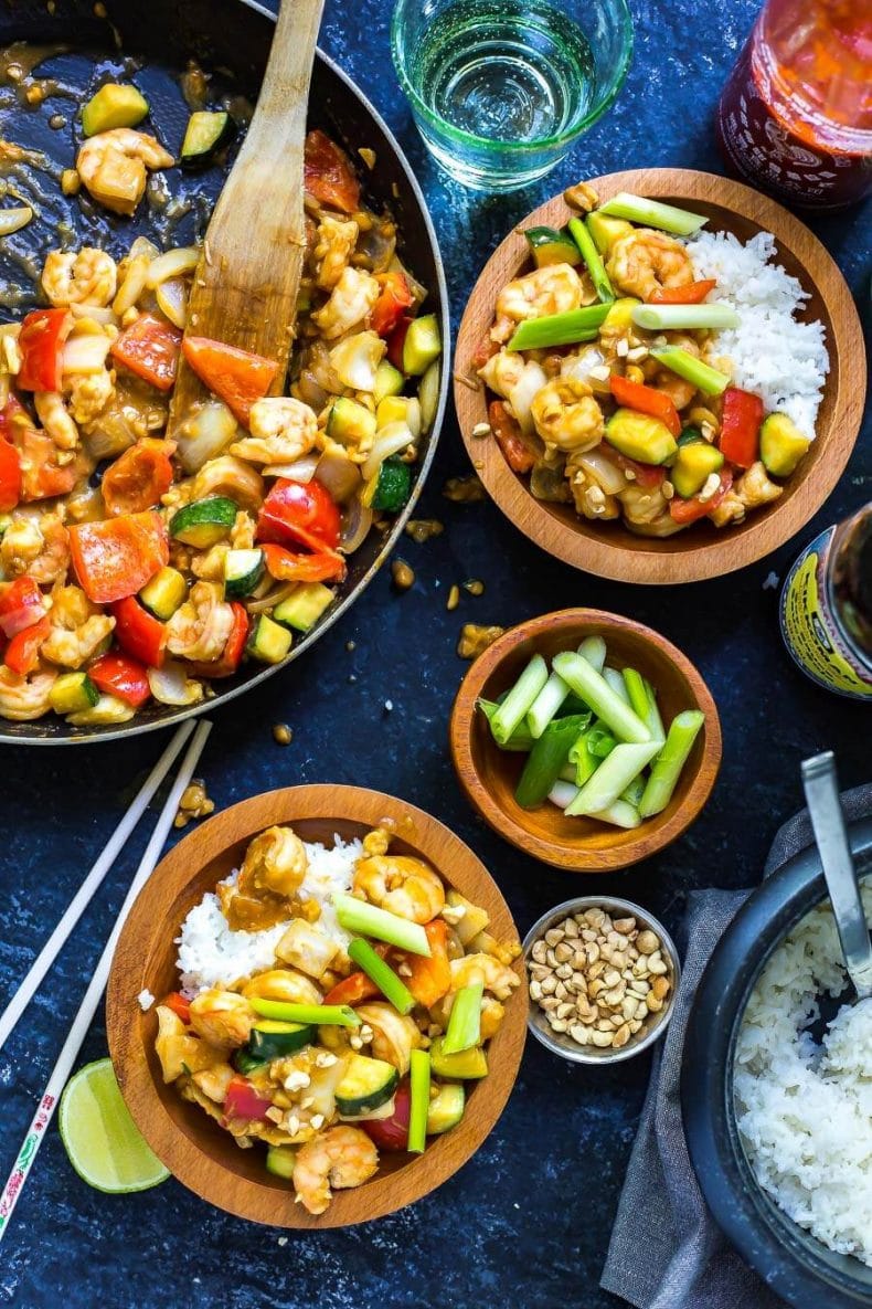 spicy Chinese shrimp stir-fry in a skillet and bowls