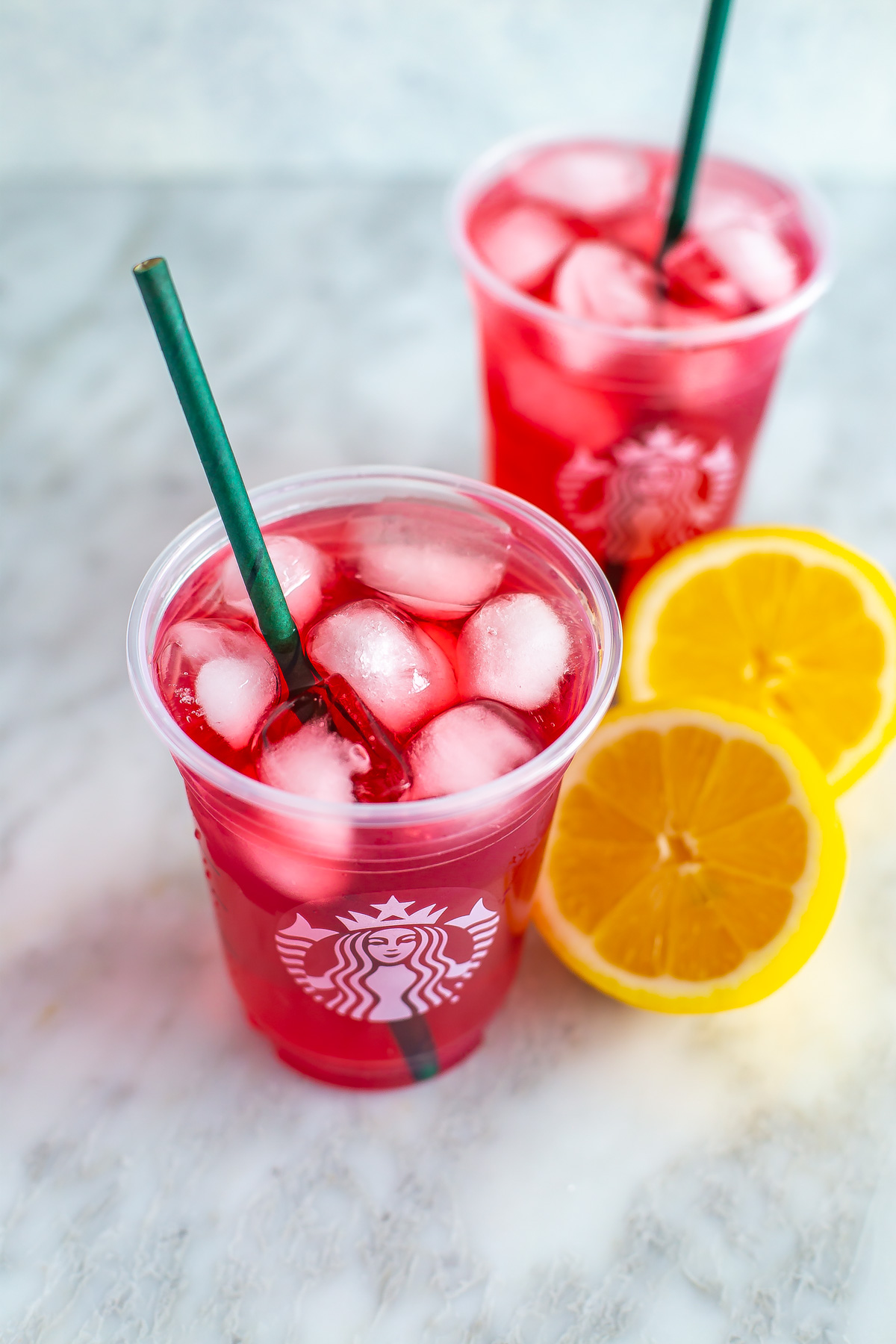 An overhead view of two cups of homemade Starbucks passion tea lemonade.