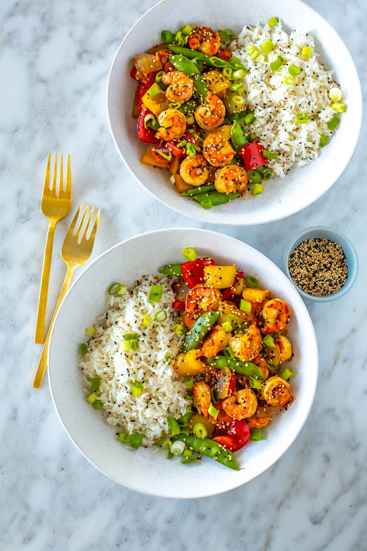 Two bowls, each with a serving of honey garlic shrimp stir fry with a side of rice.