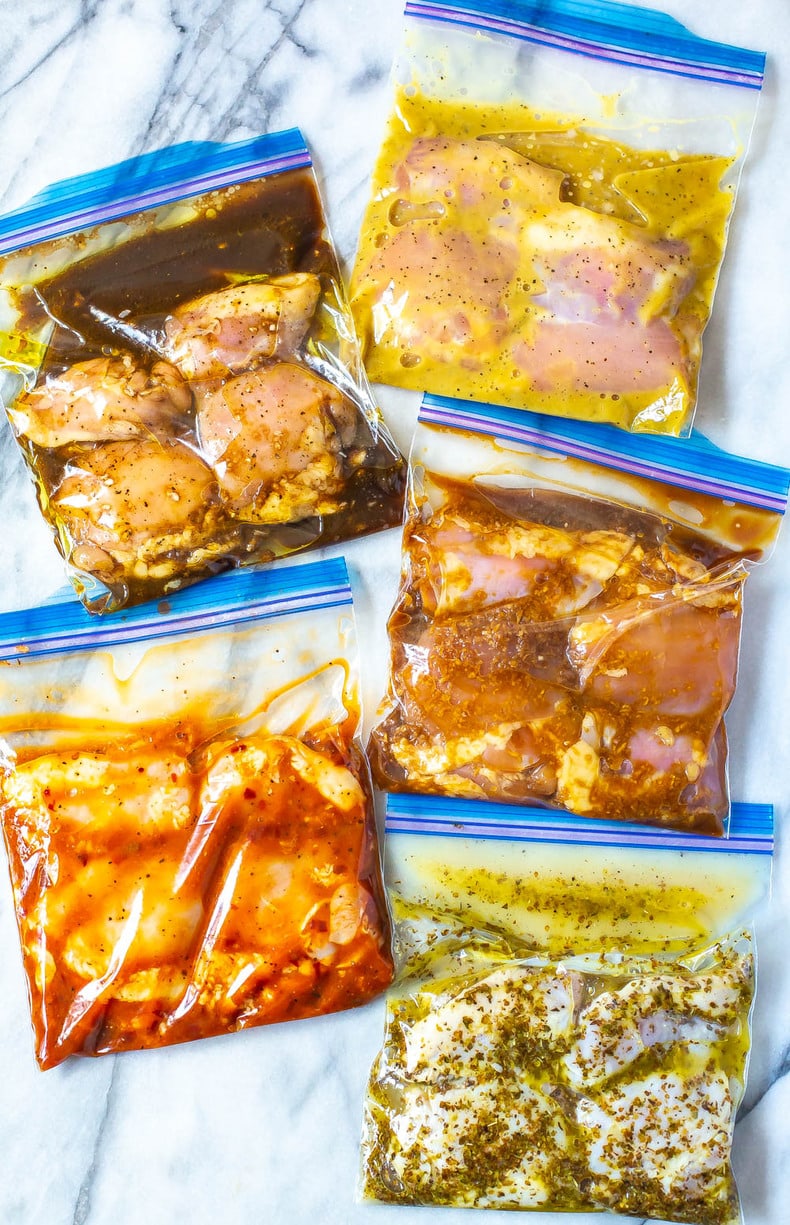 Five freezer bags filled with marinated chicken thighs.
