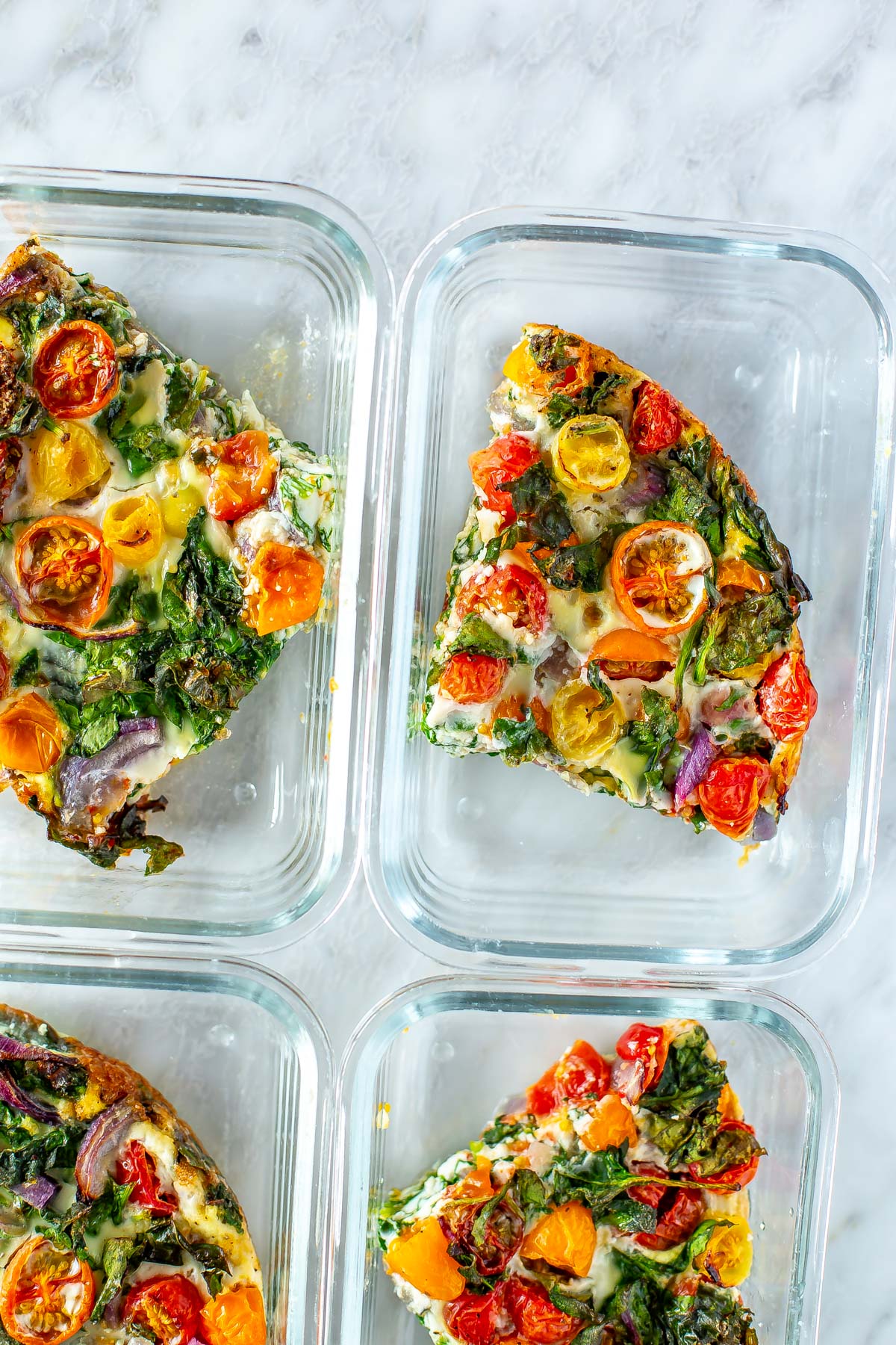 A close-up of egg white frittata in glass meal prep containers.