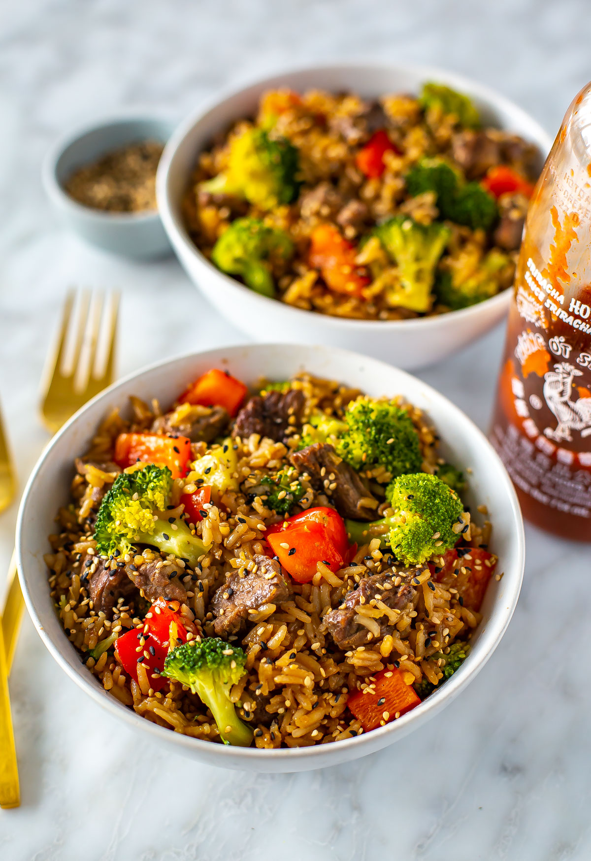 Two bowls of Instant Pot beef and broccoli, one in the foreground and one in the background.