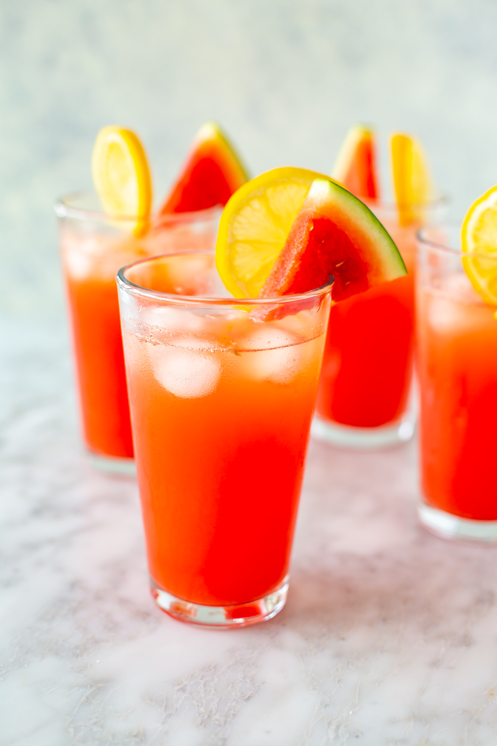 A few tall glasses filled with watermelon lemonade.