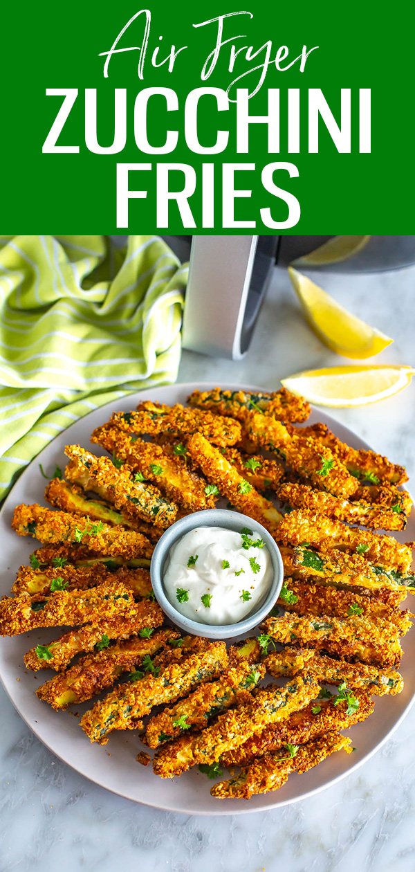 A plate of air fryer zucchini fries with garlic aioli in front of an air fryer. #airfryer #zucchinifries