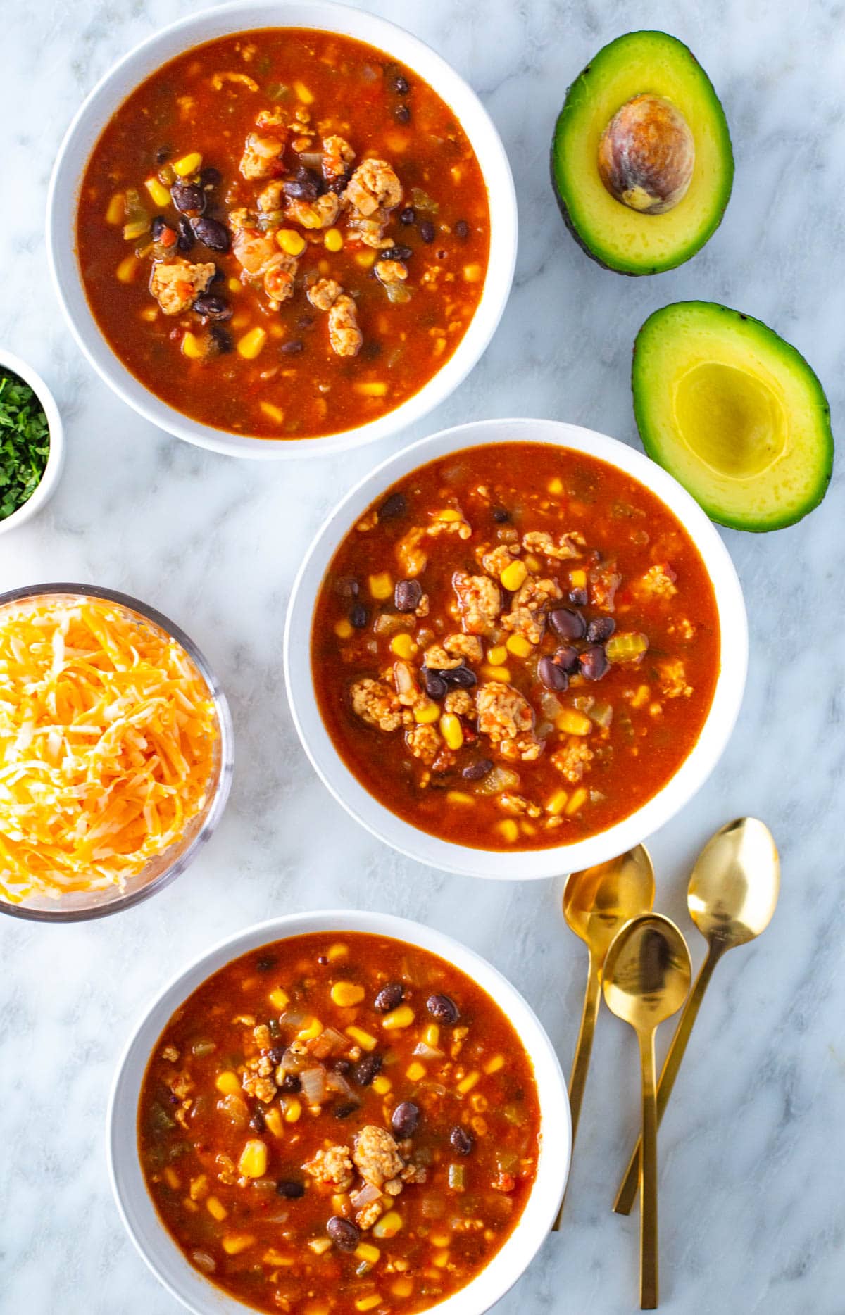 Southwest chili in three bowls with toppings